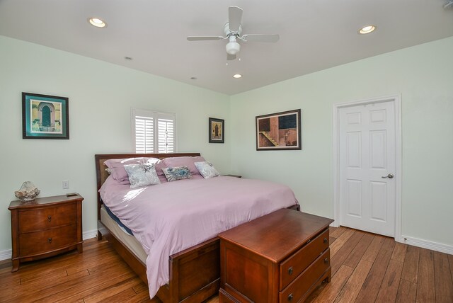 bedroom with dark hardwood / wood-style flooring and ceiling fan