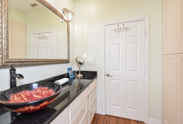 bathroom with oversized vanity, hardwood / wood-style flooring, and double sink