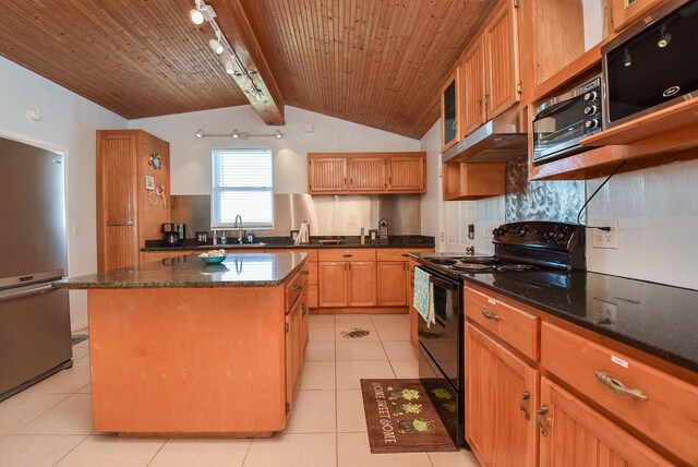 kitchen featuring light tile floors, a kitchen island, lofted ceiling with beams, rail lighting, and stainless steel appliances