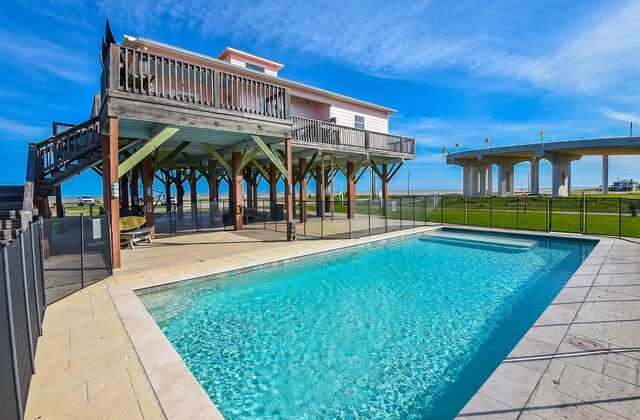 view of swimming pool with a patio, a wooden deck, and a lawn