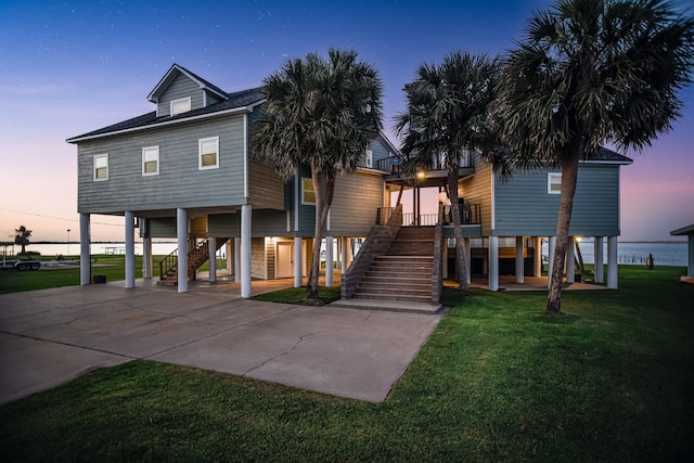 coastal inspired home featuring a carport and a lawn