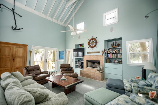 carpeted living room with a tile fireplace, ceiling fan, french doors, high vaulted ceiling, and beam ceiling