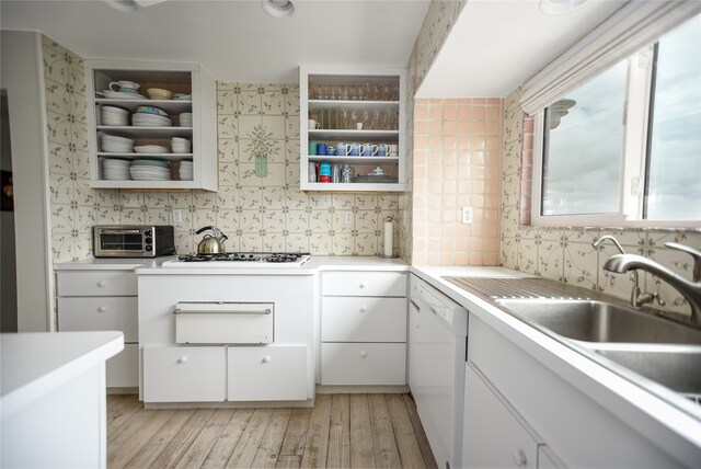 kitchen with white dishwasher, stainless steel gas cooktop, tasteful backsplash, and white cabinetry