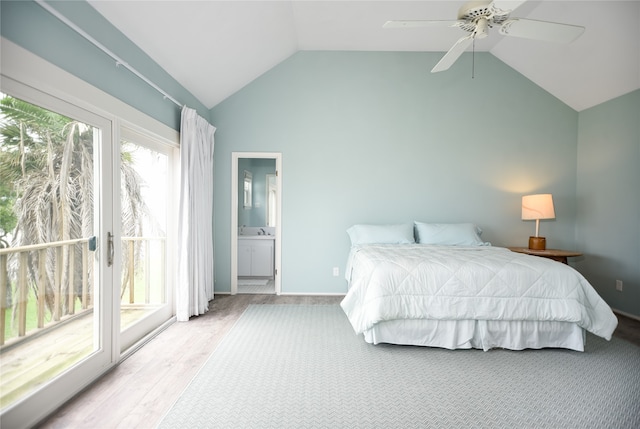 bedroom with multiple windows, ensuite bathroom, access to outside, and vaulted ceiling