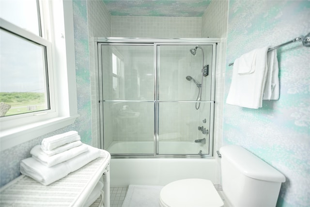 bathroom featuring tile flooring, toilet, and enclosed tub / shower combo