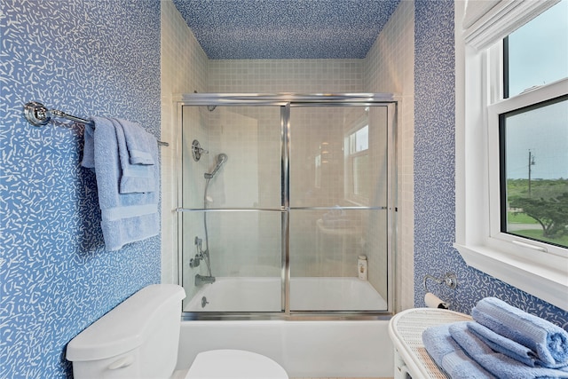 full bathroom with plenty of natural light, shower / bath combination with glass door, toilet, and vanity