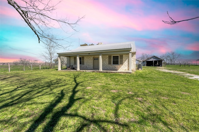 back house at dusk with a lawn