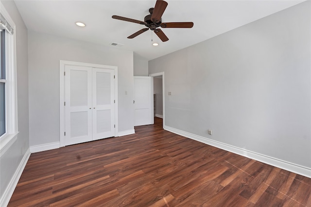 unfurnished bedroom with dark hardwood / wood-style flooring, ceiling fan, and a closet