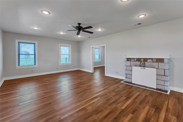 unfurnished living room featuring ceiling fan, a fireplace, and dark hardwood / wood-style floors