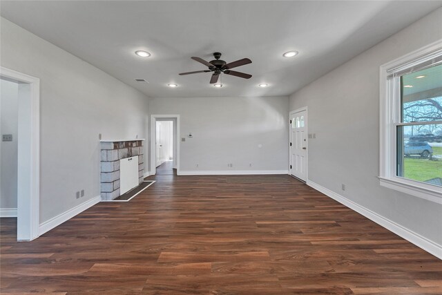 unfurnished living room featuring ceiling fan and dark hardwood / wood-style flooring