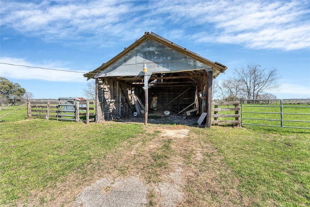 view of outdoor structure with a rural view and a lawn