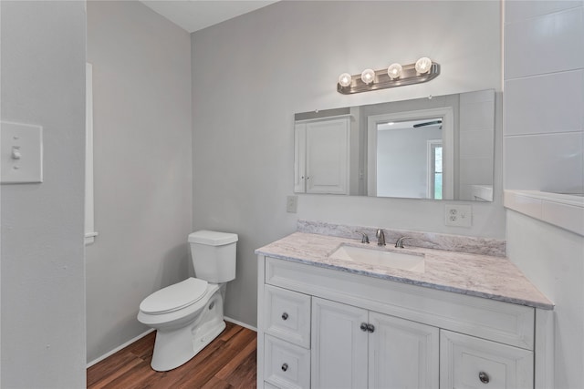 bathroom with toilet, hardwood / wood-style flooring, and vanity