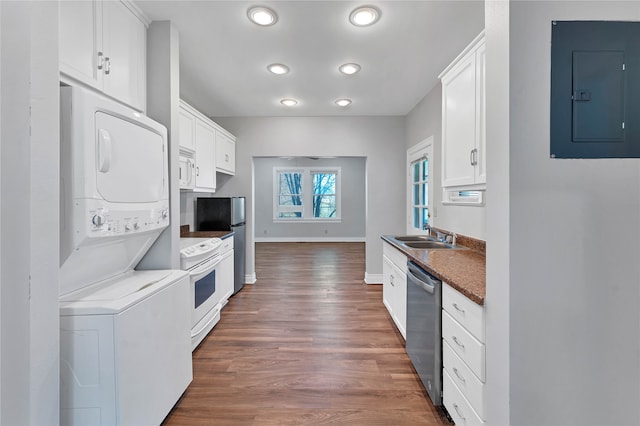 kitchen with stacked washer and clothes dryer, white appliances, dark wood-type flooring, and white cabinetry