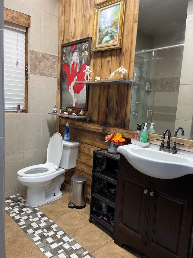 bathroom featuring tile flooring, tile walls, walk in shower, toilet, and vanity