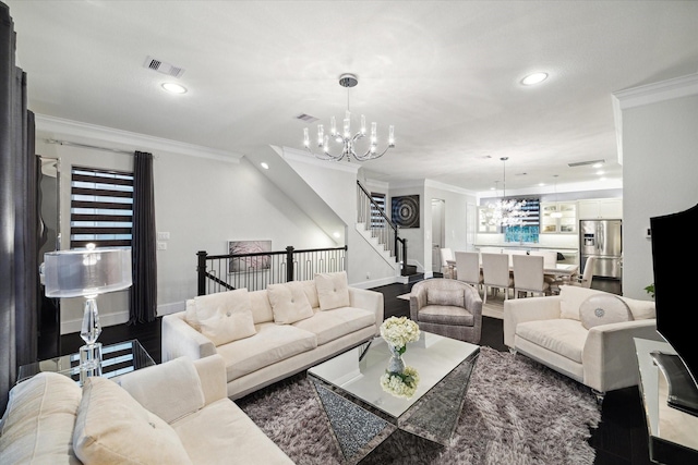 living room with hardwood / wood-style floors, ornamental molding, and a chandelier