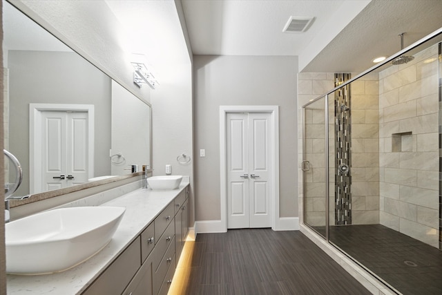 bathroom with vanity, a shower with door, and wood-type flooring