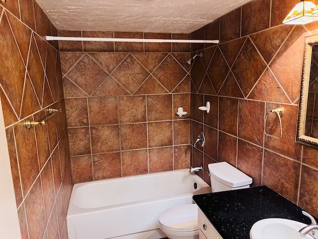 full bathroom featuring tile walls, tiled shower / bath combo, a textured ceiling, toilet, and oversized vanity