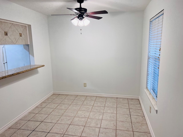 tiled empty room featuring ceiling fan