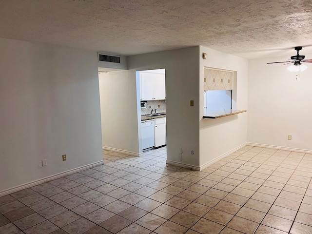 tiled spare room featuring sink, a textured ceiling, and ceiling fan