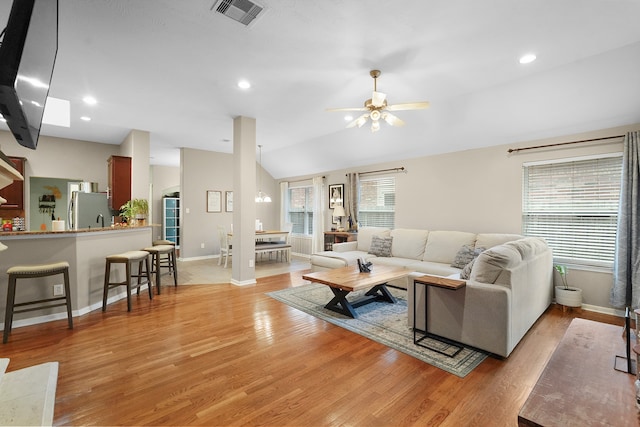 living room featuring lofted ceiling, ceiling fan, and light wood-type flooring