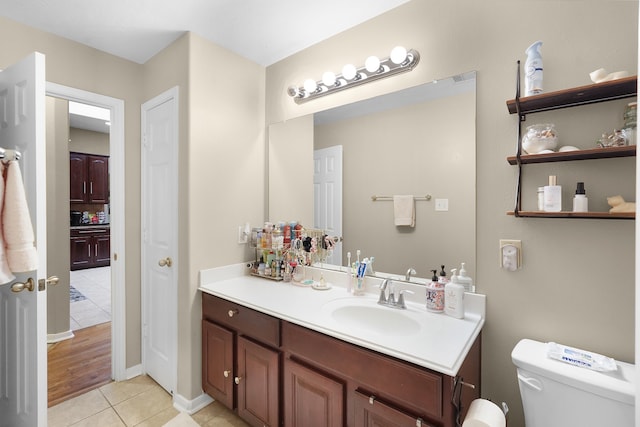 bathroom with tile flooring, vanity, and toilet