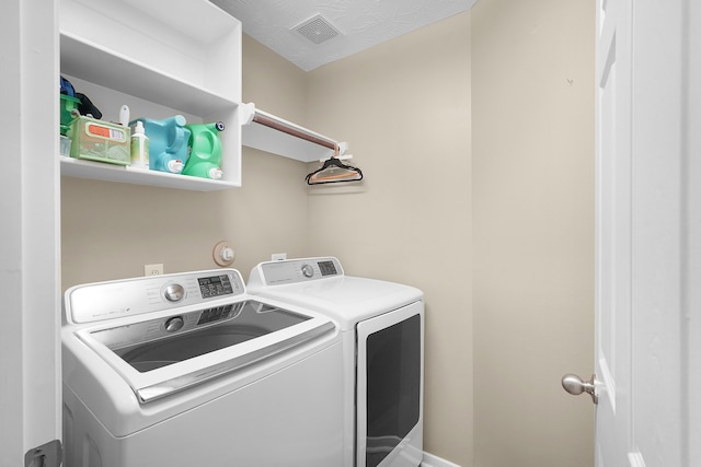 laundry area with washer and dryer and a textured ceiling