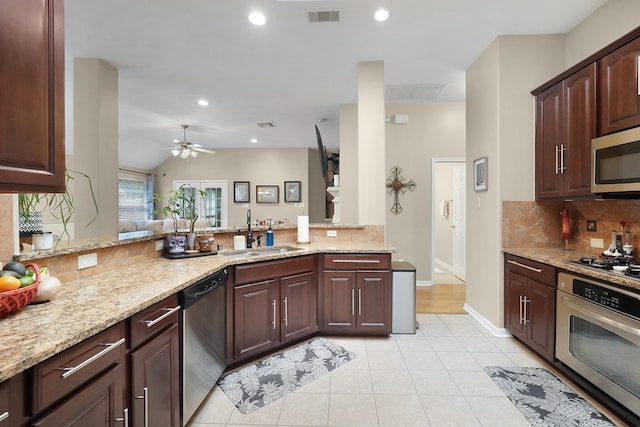 kitchen with light stone counters, appliances with stainless steel finishes, ceiling fan, sink, and tasteful backsplash