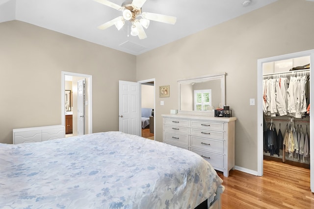 bedroom with a closet, light hardwood / wood-style floors, ceiling fan, a walk in closet, and lofted ceiling