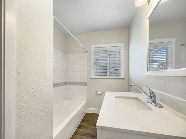 bathroom with tiled shower / bath combo, oversized vanity, and hardwood / wood-style flooring