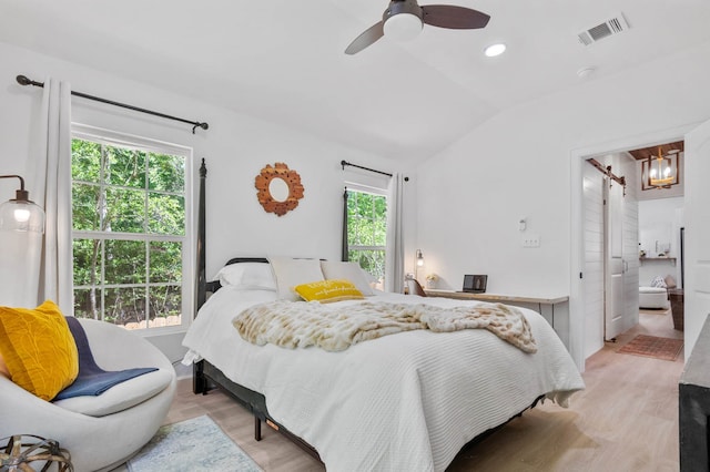 bedroom with multiple windows, ceiling fan with notable chandelier, and light hardwood / wood-style floors