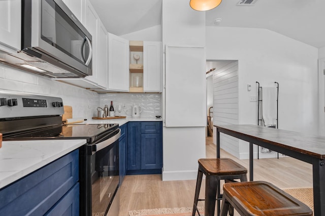 kitchen with stainless steel appliances, light hardwood / wood-style floors, blue cabinetry, lofted ceiling, and tasteful backsplash