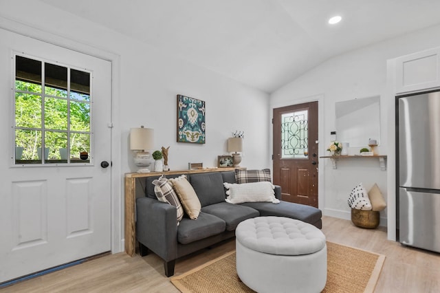 living room with vaulted ceiling and light hardwood / wood-style flooring