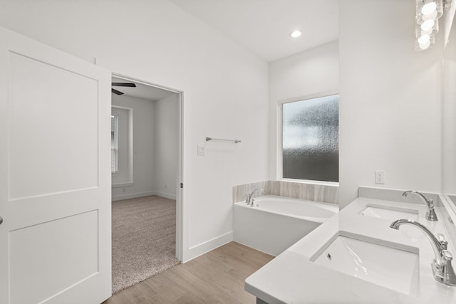 bathroom featuring ceiling fan, a bathtub, hardwood / wood-style floors, and vanity