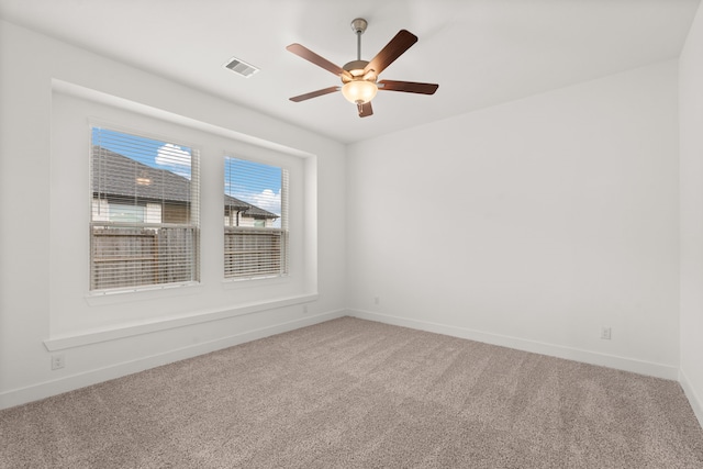 unfurnished room with ceiling fan and carpet