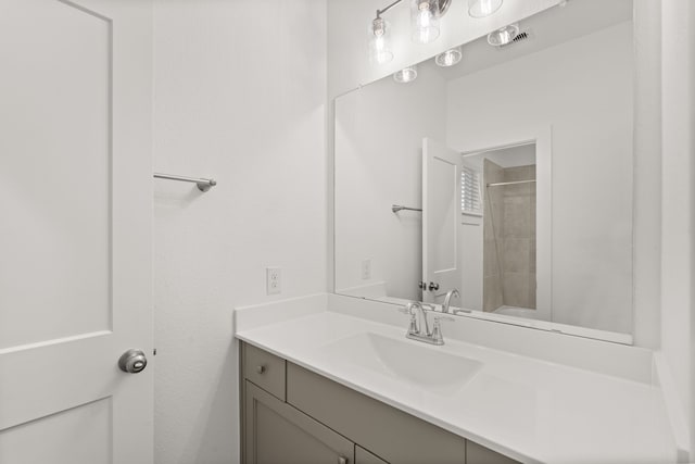 bathroom featuring a tile shower and vanity