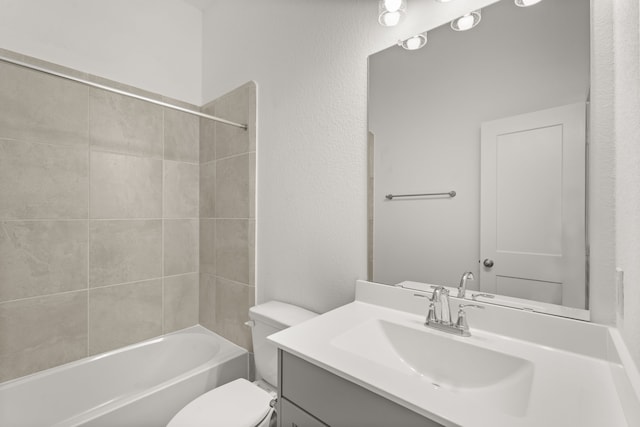 full bathroom featuring toilet, tiled shower / bath combo, and vanity