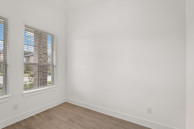 spare room with hardwood / wood-style floors and plenty of natural light