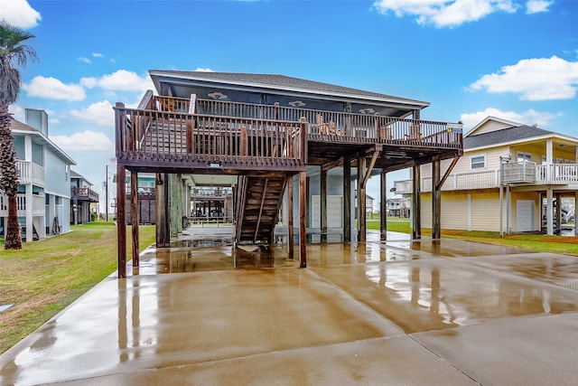 back of property featuring a deck, a balcony, and a yard