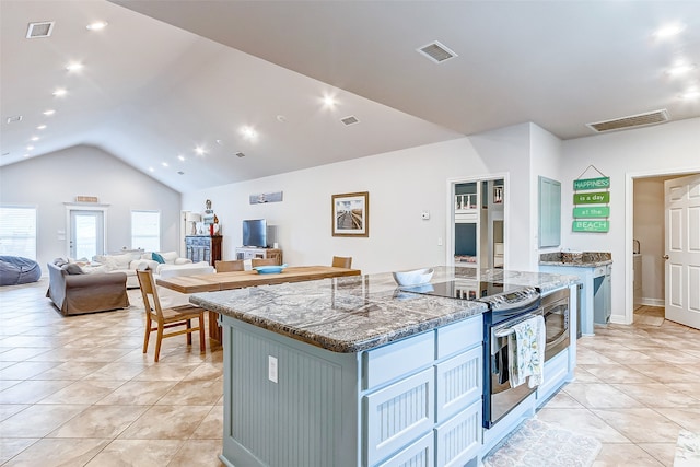 kitchen with dark stone countertops, light tile floors, stainless steel electric stove, a center island, and lofted ceiling