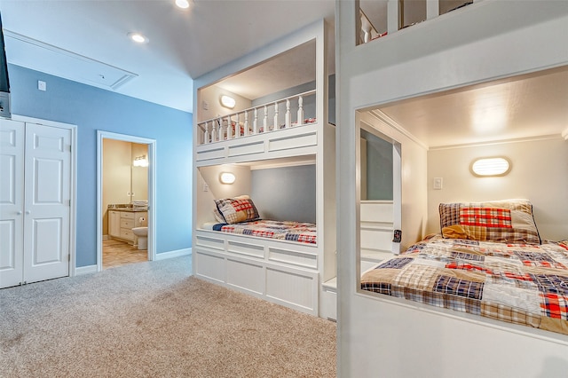 bedroom with light colored carpet and ensuite bathroom