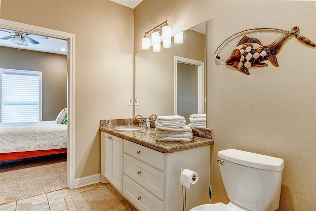 bathroom featuring ceiling fan, toilet, tile floors, and vanity