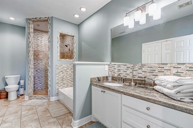 full bathroom featuring tile floors, independent shower and bath, backsplash, toilet, and vanity with extensive cabinet space