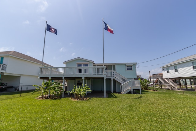 rear view of property featuring stairway, a lawn, and a deck