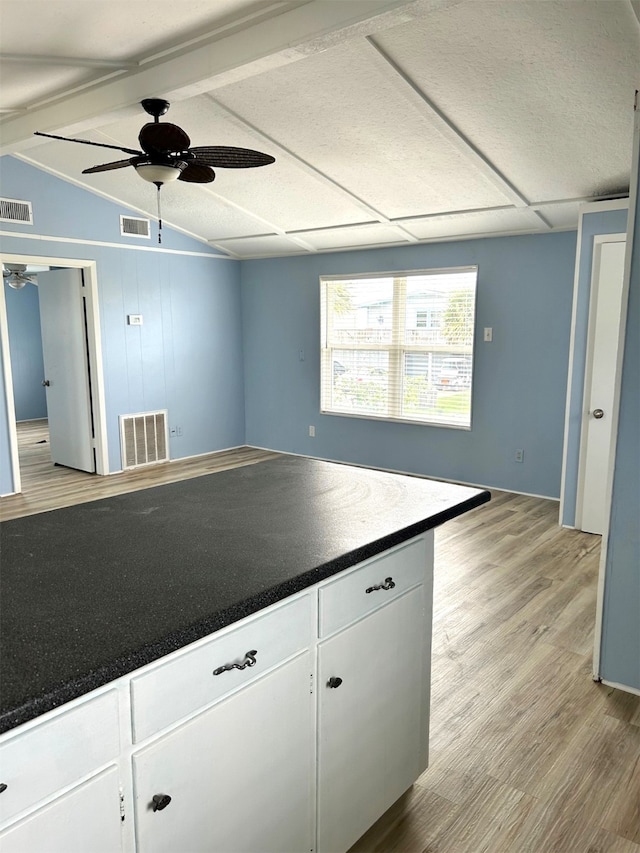 kitchen featuring dark countertops, visible vents, light wood finished floors, and ceiling fan