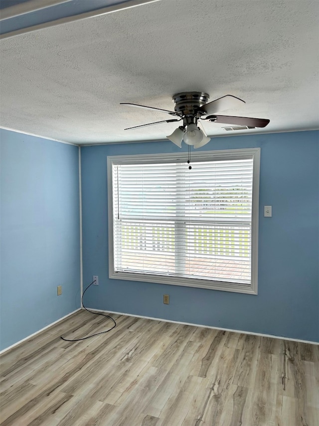 spare room featuring a textured ceiling, a ceiling fan, and wood finished floors