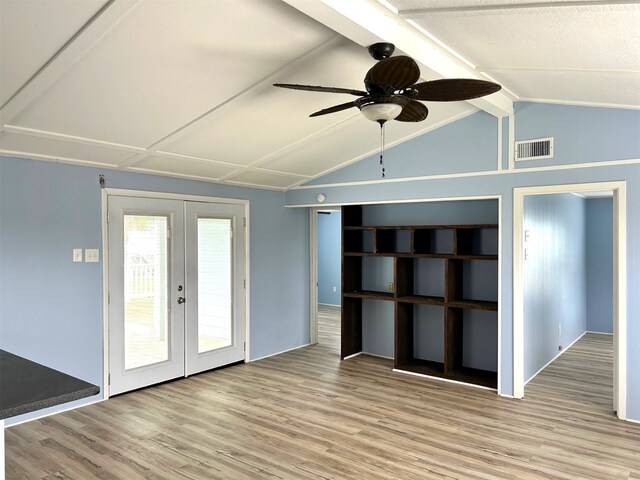 unfurnished living room featuring wood finished floors, visible vents, lofted ceiling with beams, ceiling fan, and french doors