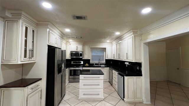 kitchen featuring stainless steel appliances, white cabinetry, and backsplash