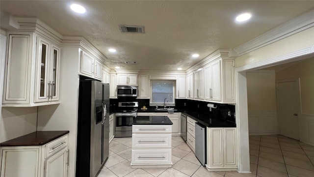 kitchen featuring light tile patterned floors, decorative backsplash, stainless steel appliances, and white cabinets