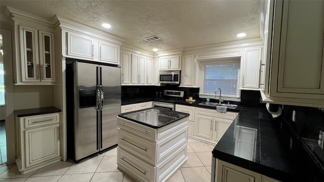 kitchen with a center island, stainless steel appliances, backsplash, sink, and light tile floors