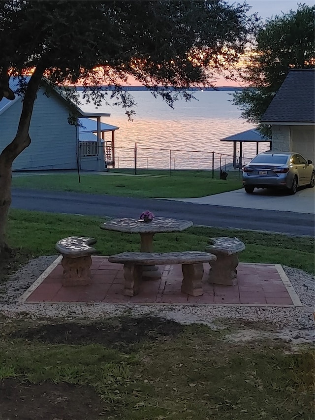 view of property's community featuring a lawn and a water view